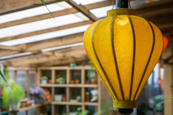 Close Up Photo of Yellow Hanging Lantern inside a Cafe with Wooden Design