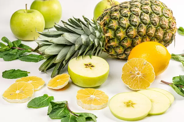 Close-up, pineapple with lemon, apple and mint leaves