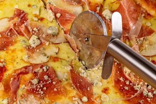 Close up, pizza with pear, dorblu cheese and knife