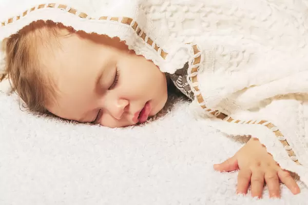 Close-up portrait of a beautiful sleeping baby on a soft bed