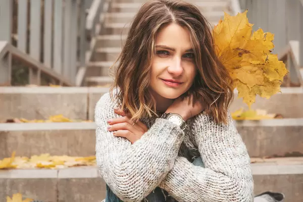 Close-up portrait of a girl with autumn leaves