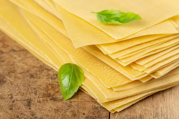 Close-up, raw lasagna sheets, old wood background