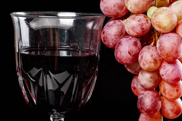 Close-up, red wine in a glass and fresh grapes