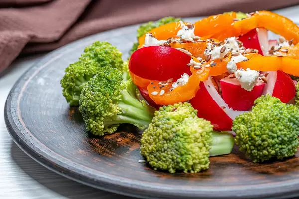 Close-up salad of broccoli, radish, bell pepper with seeds