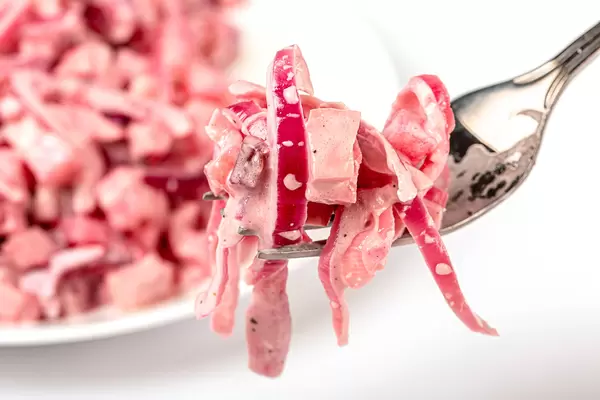 Close-up, salad on a fork with vegetables and boiled sausage