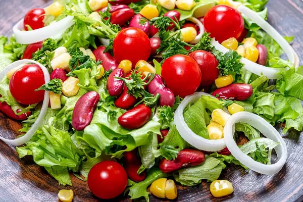 Close-up salad with beans, corn, tomatoes, lettuce, leeks and greens (Flip 2019)