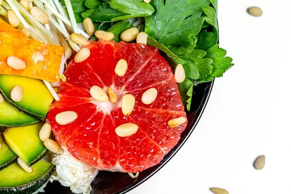 Close-up salad with grapefruit, avocado, micro greenery and pine nuts (Flip 2020)