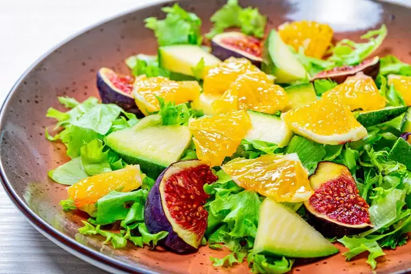 Close-up salad with lettuce, oranges, figs and mango on a plate (Flip 2019)