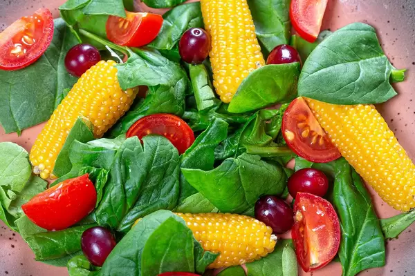 Close-up salad with spinach, tomatoes, corn and dogwood (Flip 2019)