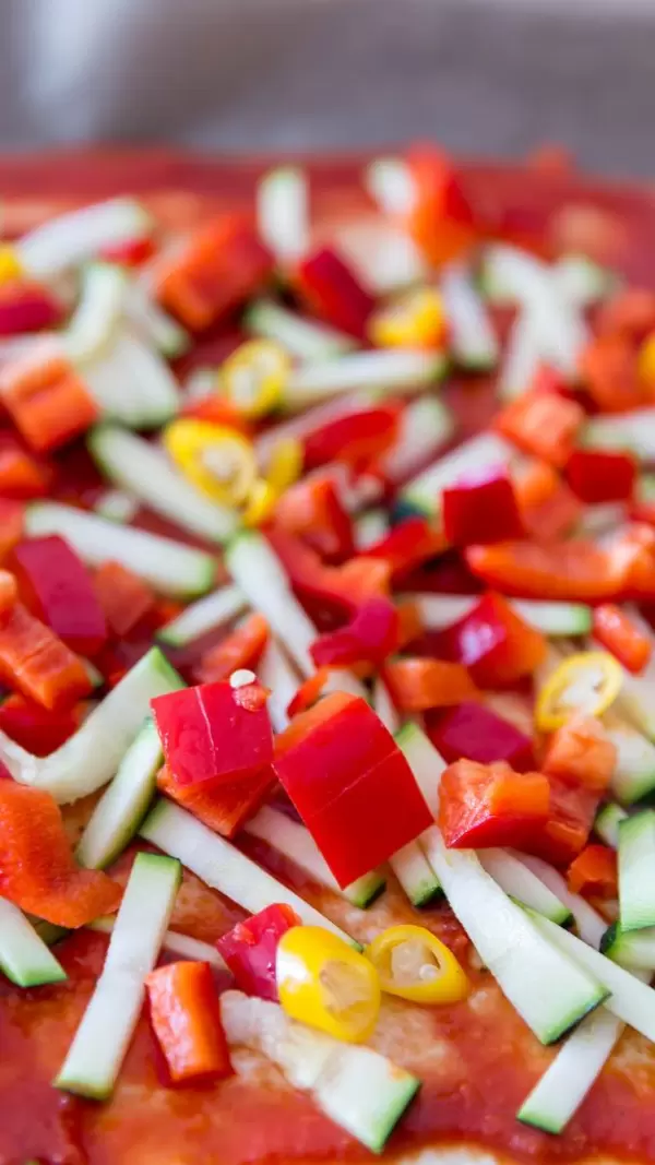 Close-up shot of a veggie pizza with peppers and zucchini