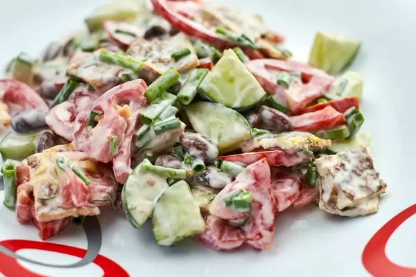 Close-up shot of healthy salad made with sour cream, tomato, cucumber and red kidney beans