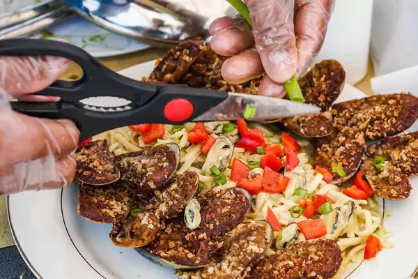 Close up shot of person preparing a pasta dish