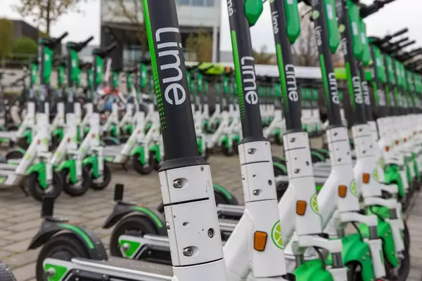 Close-up shot of various rows of Lime e-scooters parked in Cologne