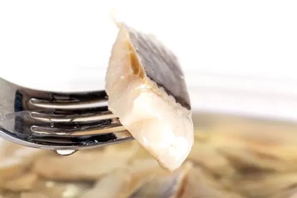 Close-up, slice of pickled herring on a fork