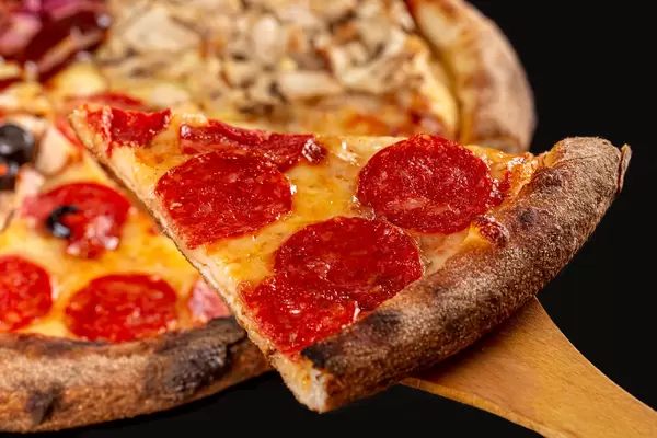 Close-up, slice of pizza with salami and cheese