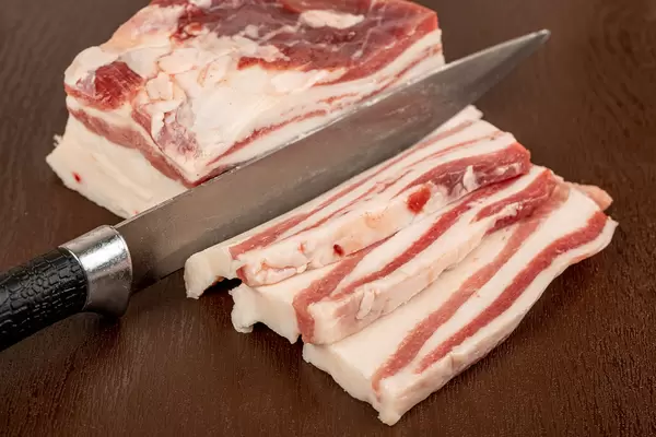 Close-up sliced pork bacon with a knife