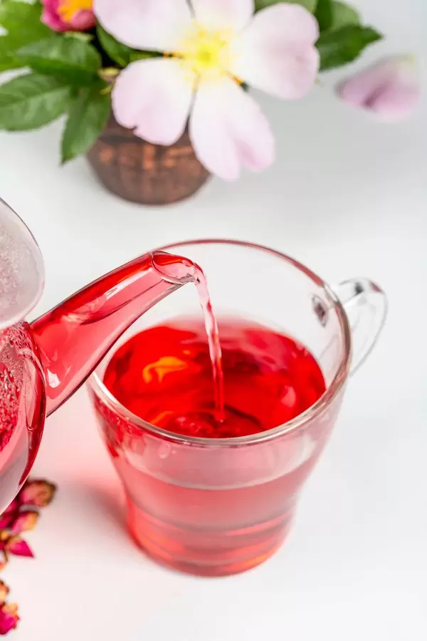 Close-up, tea is poured from a teapot into a glass cup