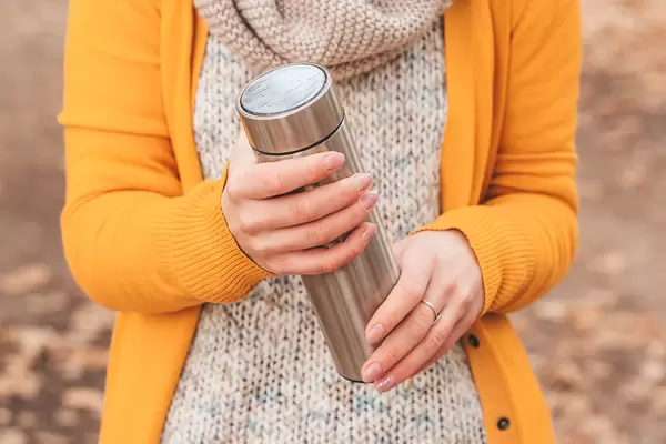 Close-up, thermos in women's hands
