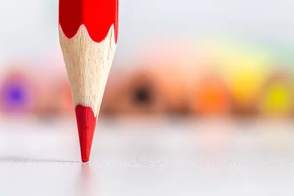 Close-up, tip of red pencil with colored pencils behind