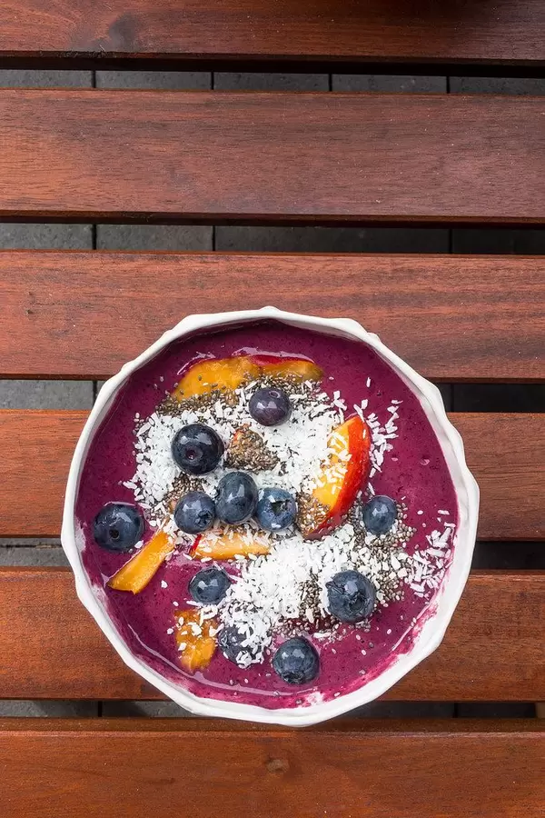 Close Up Top View Food Photo of Healthy Acai Bowl with Blueberry, Coconut Rasp and Peach