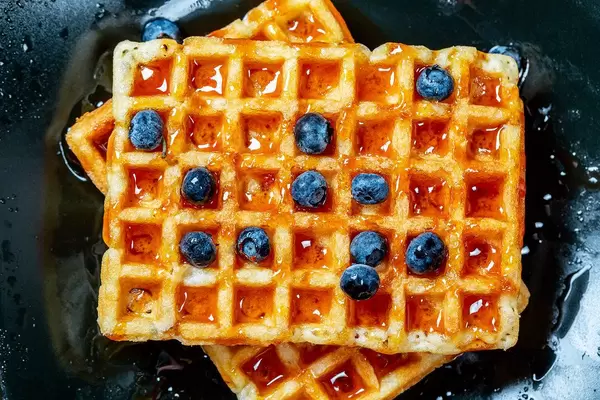 Close Up Top View Food Photo of Honey Glazed Belgian Waffles topped with Blueberries