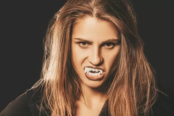 Close up, vampire woman's face on dark background