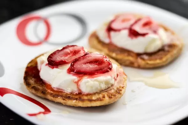 Close-up view of gluten-free oatmeal pancakes with fresh fruits and yogurt for healthy breakfast