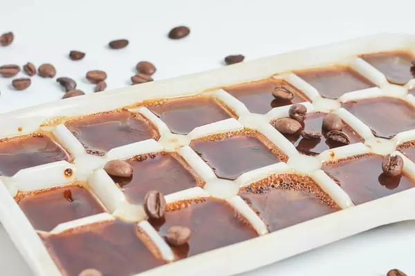 Close-up view of iced coffee cubes and beans