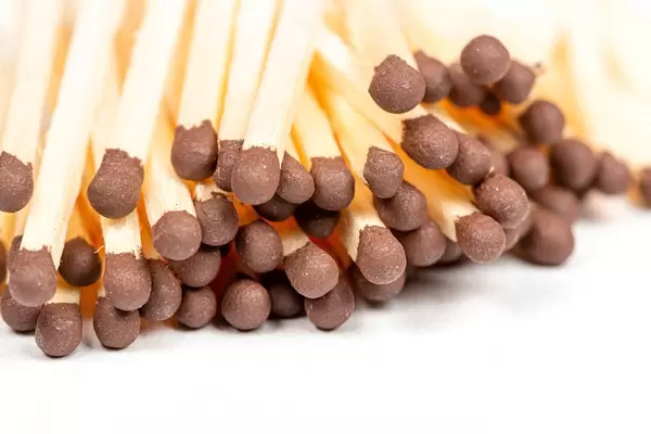 Close-up von Streichhölzern mit braunem Kopf auf weißem Hintergrund