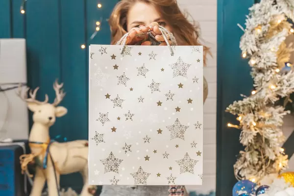 Close-up, white gift bag in female hands