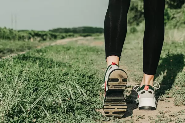 Close-up, women's feet in sneakers in nature. Concept of running, active lifestyle