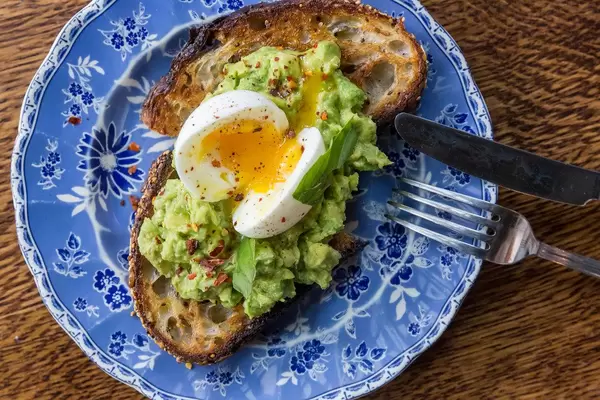 Closeup from above of blue vintage plate with multigrain toast with boiled egg and avocado served for breakfast at The Allis in Chicago Downtown