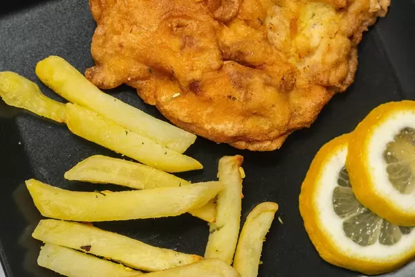 Closeup image of Vienna Steak with french fries and lemons