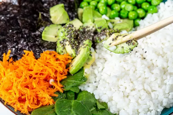 Closeup of a slice of avocado with Chia seeds with the chopsticks. Healthy diet (Flip 2019)