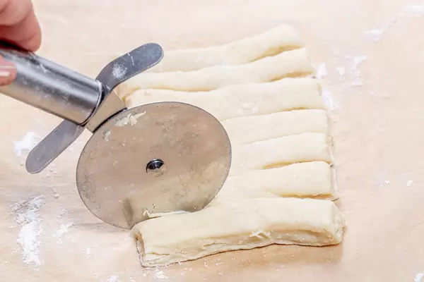 Closeup of cutting the dough for the buns