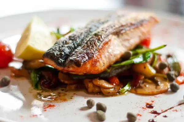 Closeup of plate of delicious fish with vegetables at a fancy restaurant