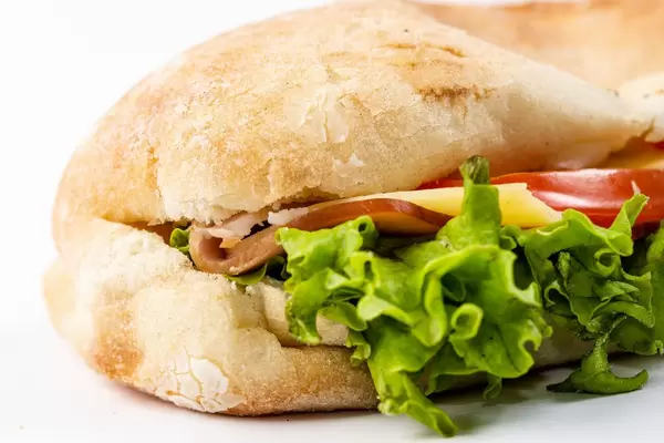 Closeup on Sandwich with Lettuce Cheese Ham and Tomato on white background (Flip 2019)