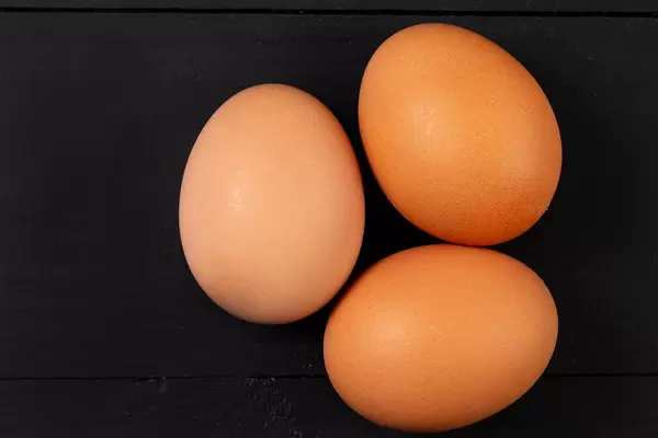 Closeup on Three Chicken Eggs on the black background