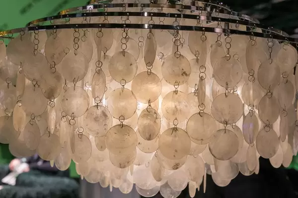 Closeup playful lamp with chains of thin round glass plates on several metal rings