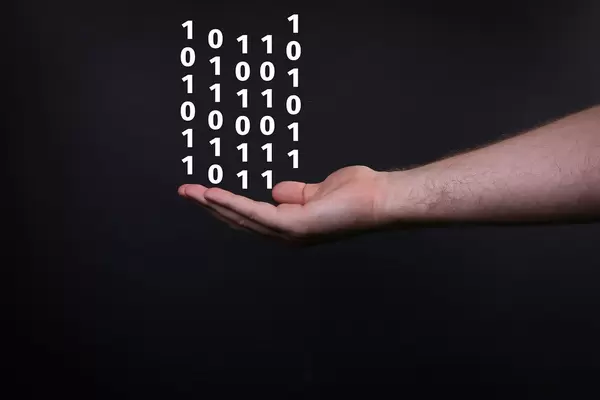 Closeup shot of male hand and binary code isolated on black background