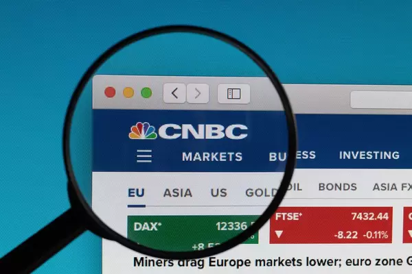 CNBC Logo und Schriftzug, des britischen Nachrichtensenders für Finanzen und Wirtschaft, unter einem Lupenglas