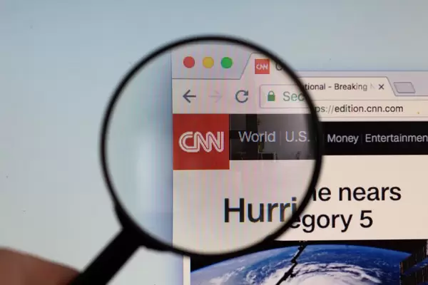 CNN logo on a computer screen with a magnifying glass