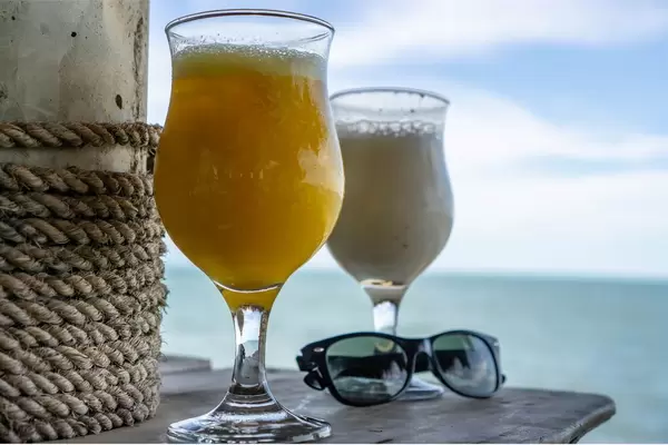 Cocktails and Sunglasses on a Table with Seaview in the Background
