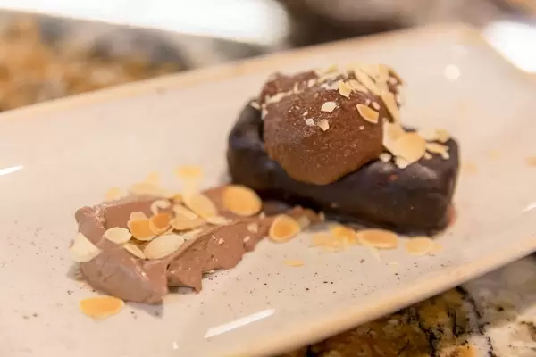 Coco Choclate dessert with almond flakes on a white plate at Fit Kitchen in Barcelona, Spain