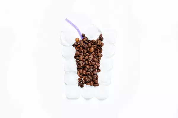 Coffee beans and ice cubes in form of cocktail glass
