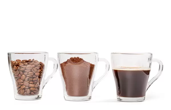 Coffee beans, ground coffee and cup of black coffee over white background