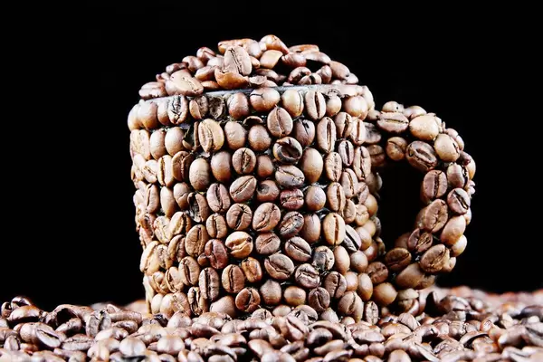 Coffee beans in a cup, black background