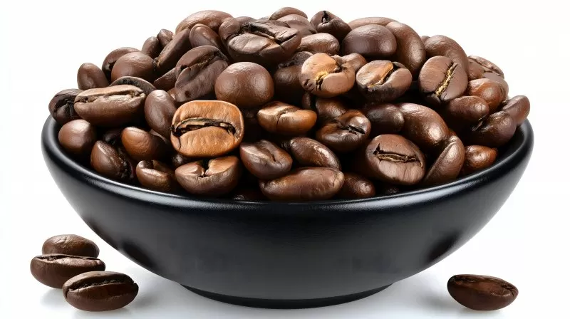 Coffee beans in black ceramic bowl on white