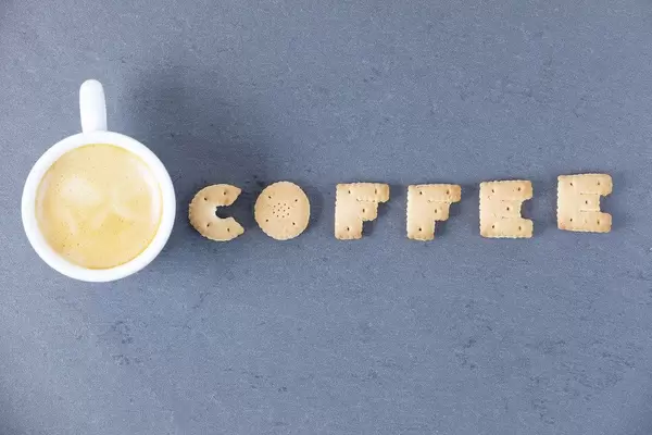 Coffee letters of biscuit and coffee cup, dark background