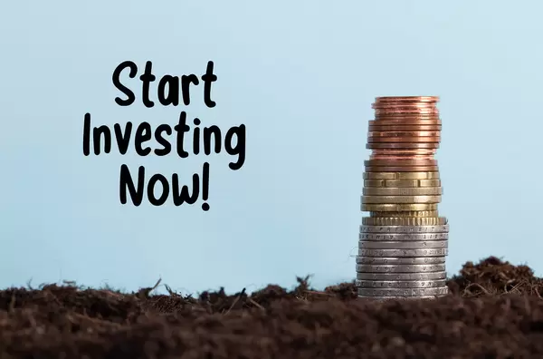 Coin stack on a dirt and Start Investing Now text